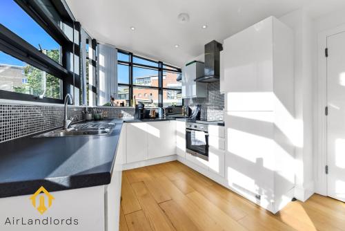 a kitchen with white counters and a large window at Exclusive 2 Bedroom Flat near Buckingham Palace in London