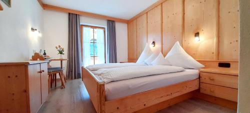 a bedroom with a bed with a wooden wall at Knapphof in Reit im Winkl