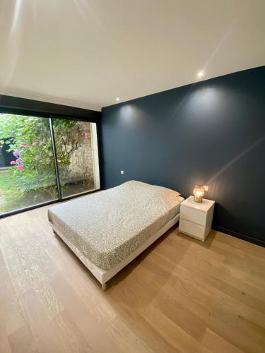 um quarto com uma cama e uma grande janela em Loft Rochegude em Albi