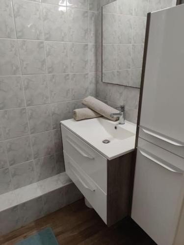 une salle de bain avec un lavabo blanc et un miroir dans l'établissement *Le Super Land* Parking Privé * Cadre verdoyant*, à La Grande Motte