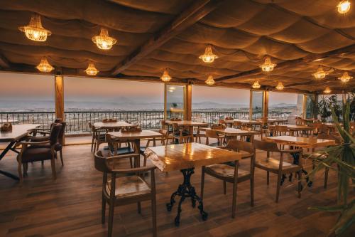 a restaurant with tables and chairs and views of the ocean at Hu of Cappadocia - Special Class in Uchisar