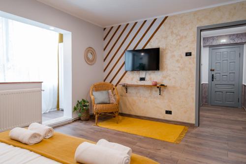 Habitación con cama y TV en la pared. en NEW Iorga2 OldCity SelfCheckIn, en Timisoara