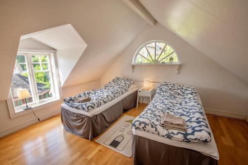 a attic room with two beds and a window at Modern house in Ronneby near lake and sea in Ronneby
