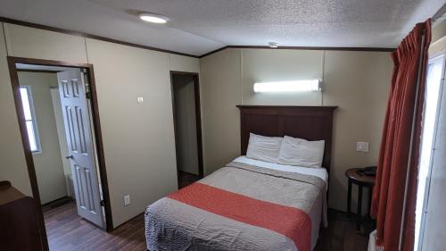 een hotelkamer met een bed met een rode deken bij Hillcrest Inn & Suites Ozona in Ozona