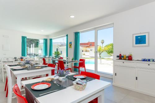 a kitchen and dining room with tables and red chairs at B & b Venere in Paestum