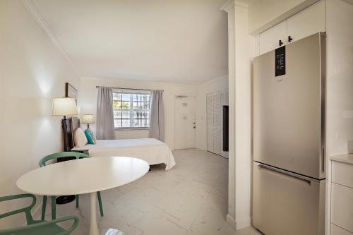 a room with a bed and a table and a refrigerator at La Mer Suites in Fort Lauderdale
