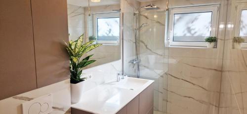 a white bathroom with a sink and a shower at Greenline by Gregory - Apartment mit Garten in Mainz, ZDF Nähe in Mainz