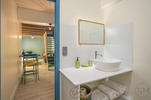 ein Badezimmer mit einem weißen Waschbecken und einem Spiegel in der Unterkunft Foyal City Center in Fort-de-France