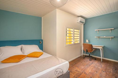 Schlafzimmer mit einem Bett, einem Schreibtisch und einem Fenster in der Unterkunft Foyal City Center in Fort-de-France
