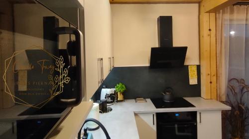 uma cozinha com um lavatório e um fogão forno superior em CHWILO TRWAJ - dom z kominkiem i pięknym widokiem na góry em Korbielów