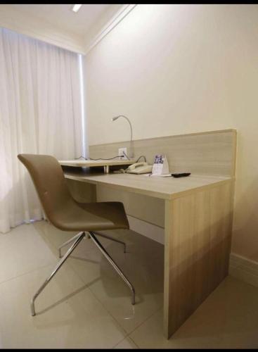 a desk with a chair in a room at Flat in Brasilia