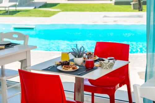 a table with a plate of food and two red chairs at B & b Venere in Paestum