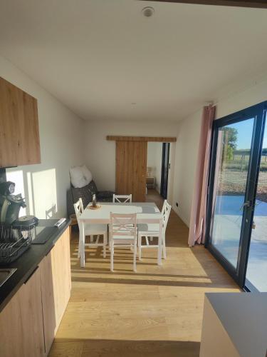 une cuisine et une salle à manger avec une table et des chaises dans l'établissement Domaine du Moulin Neuf aux portes de Beauval, à Nouans-les-Fontaines