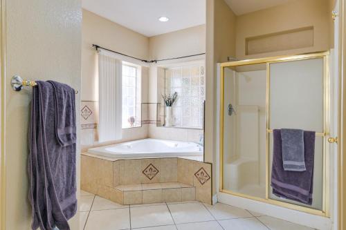 a bathroom with a tub and a glass shower at Luxe Yuma Home with Private Pool! in Yuma