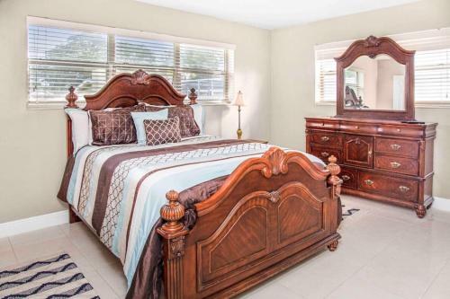 een slaapkamer met een groot houten bed en een dressoir bij Miami 3BR Cozy Home w/ Spacious Yard in Miami
