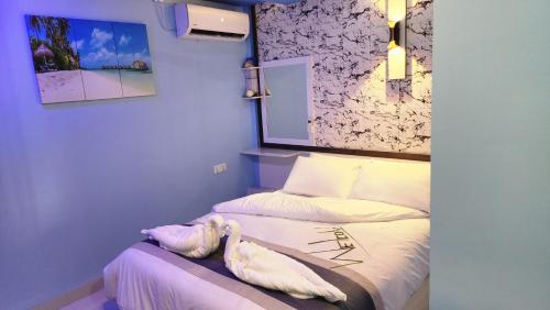 Isle inn في Fuvahmulah: غرفة نوم بسريرين مع شراشف بيضاء