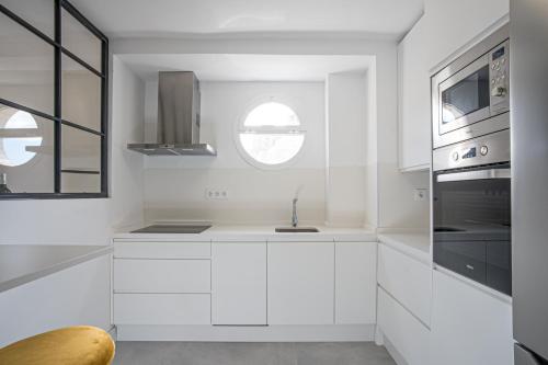 cocina blanca con fregadero y ventana en Luxury Apartment Free Parking en Sevilla