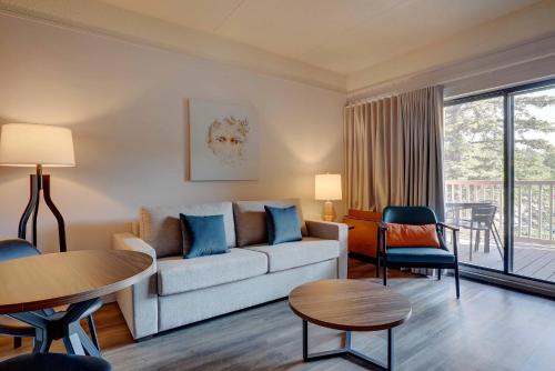 a living room with a couch and a table at Estrimont in Magog-Orford