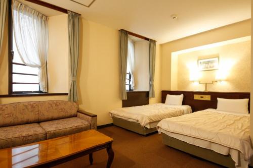 una camera d'albergo con due letti e un divano di Hotel Hanakomichi - Vacation STAY 27612v a Nara