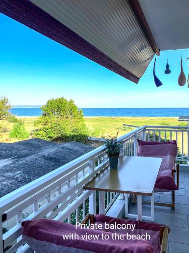 a balcony with a table and chairs and the ocean at Medusa Beach Apartment, Asprovalta in Asprovalta