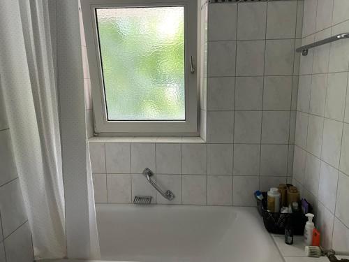 a bathroom with a bath tub with a window at Private sunny room with balkony in Bogenhausen in Munich