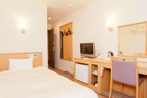 奈良市にあるHotel Hanakomichi - Vacation STAY 27567vのベッド、デスク、テレビが備わるホテルルームです。