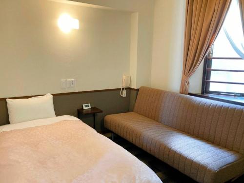奈良市にあるHotel Hanakomichi - Vacation STAY 27567vのベッドとソファ付きのホテルルーム