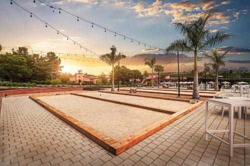 a patio with a table and chairs and palm trees at Fairmont Grand Del Mar in San Diego