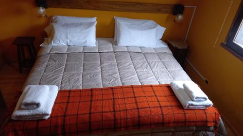 a bedroom with a bed with two towels on it at kukachalten in El Chalten