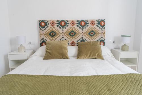 1 dormitorio con 1 cama blanca grande con almohadas en Luxury Apartment Free Parking, en Sevilla