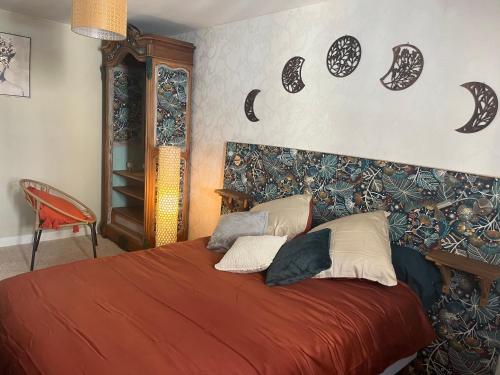 1 dormitorio con 1 cama con manta roja en Les Avatars, en Saint-Amand-Mont-Rond