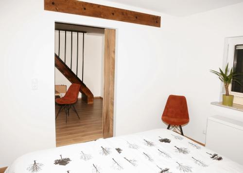 a bedroom with a bed and a chair and a staircase at Beide Bumpkes 