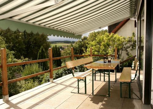 a patio with a table and chairs on a deck at Beide Bumpkes in Weitramsdorf