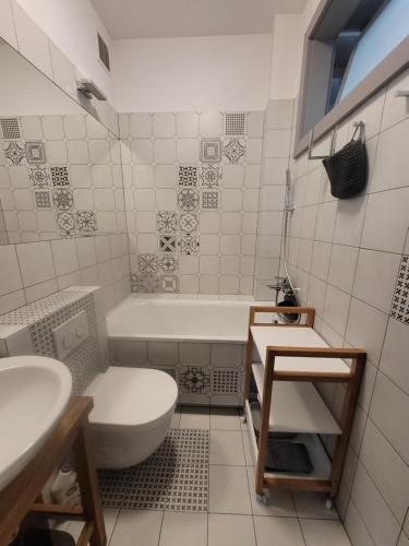 a bathroom with a tub and a toilet and a sink at Apartament Salwator Fałata in Krakow