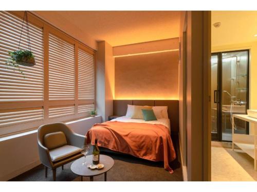 a bedroom with a bed and a chair and a table at THE BOLY OSAKA - Vacation STAY 52833v in Osaka