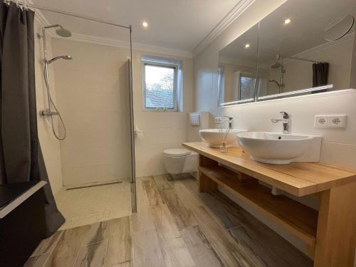 a bathroom with two sinks and a shower at Flensburg Solitüde in Flensburg