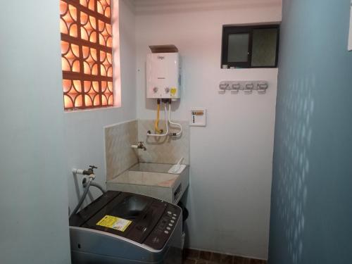 a small bathroom with a sink and a machine at Apartamento Ángel Namaste in Bello