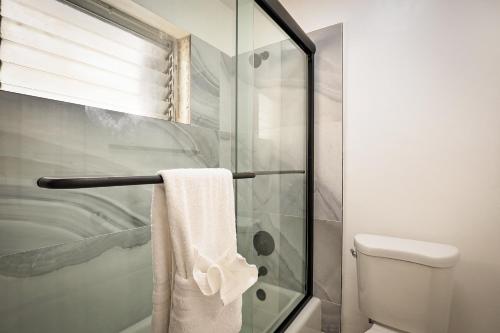 a bathroom with a shower with a toilet and a towel at La Mer Suites in Fort Lauderdale