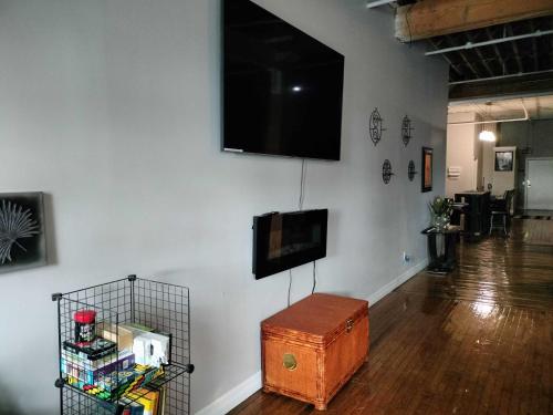 a room with a flat screen tv on a wall at Gorgeous Downtown Detroit Loft - Fully Equipped in Detroit