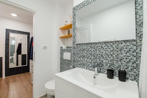 a bathroom with a white sink and a mirror at NEW Iorga3 OldCity SelfCheckIn in Timişoara