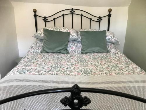 a bed with two pillows on top of it at Pipers Cottage - Quirky Cottage near Ironbridge! in Broseley