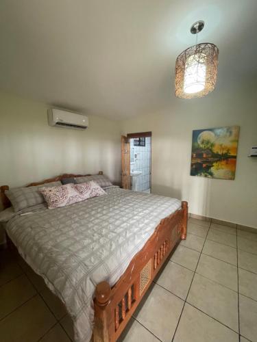 1 dormitorio con 1 cama grande en una habitación en oasis natural en un paraiso tropical, en El Espino