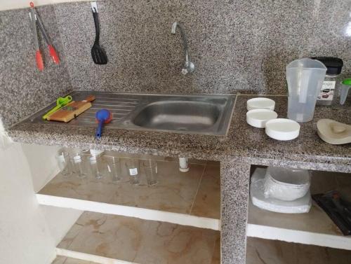 a kitchen counter with a sink and some bowls at Kiara's house in Puerto Baquerizo Moreno