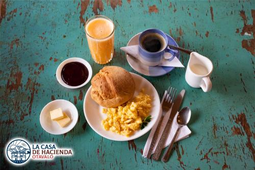 uma mesa com um prato de ovos mexidos e uma chávena de café em La Casa de Hacienda em Otavalo