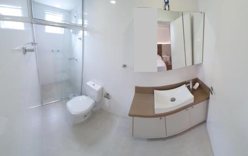 y baño con lavabo, aseo y espejo. en Apartamento Residencial Bordô amplo 3 quartos próximo à praia, en Itapema