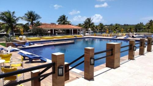 a large swimming pool with chairs and a resort at Apart-hotel Marinas do Canal in Cabo Frio