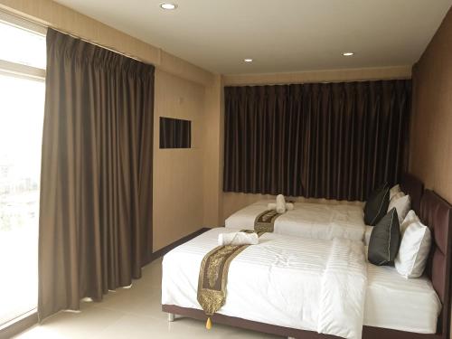 a bedroom with two beds and a large window at KS HOUSE in Bangkok