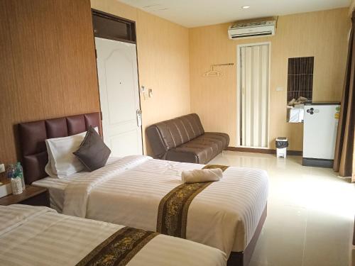 バンコクにあるKS HOUSEのベッド2台とソファが備わるホテルルームです。