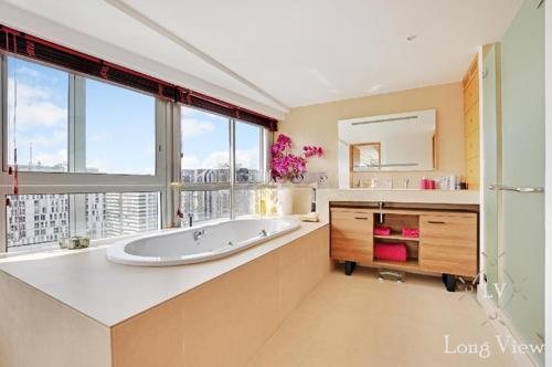 a large bathroom with a tub and a large window at Sky Terrace Eiffel Tower area in Paris