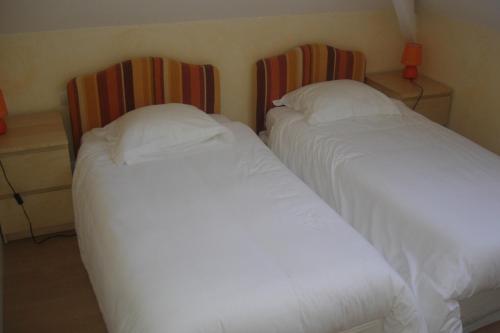 two beds sitting next to each other in a bedroom at Hotel La Bastie d'Urfé in Naussac